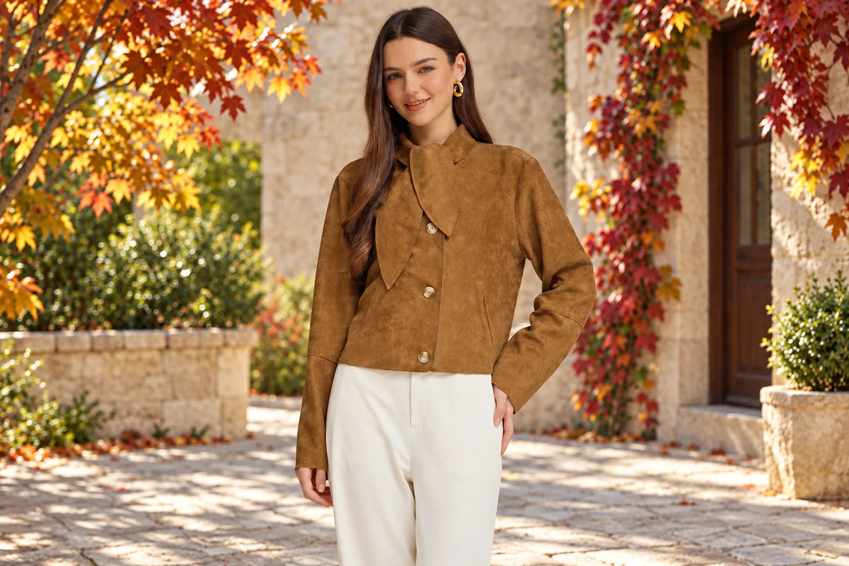Brown suede tie-neck cropped jacket styled for fall in a sunlit autumn courtyard