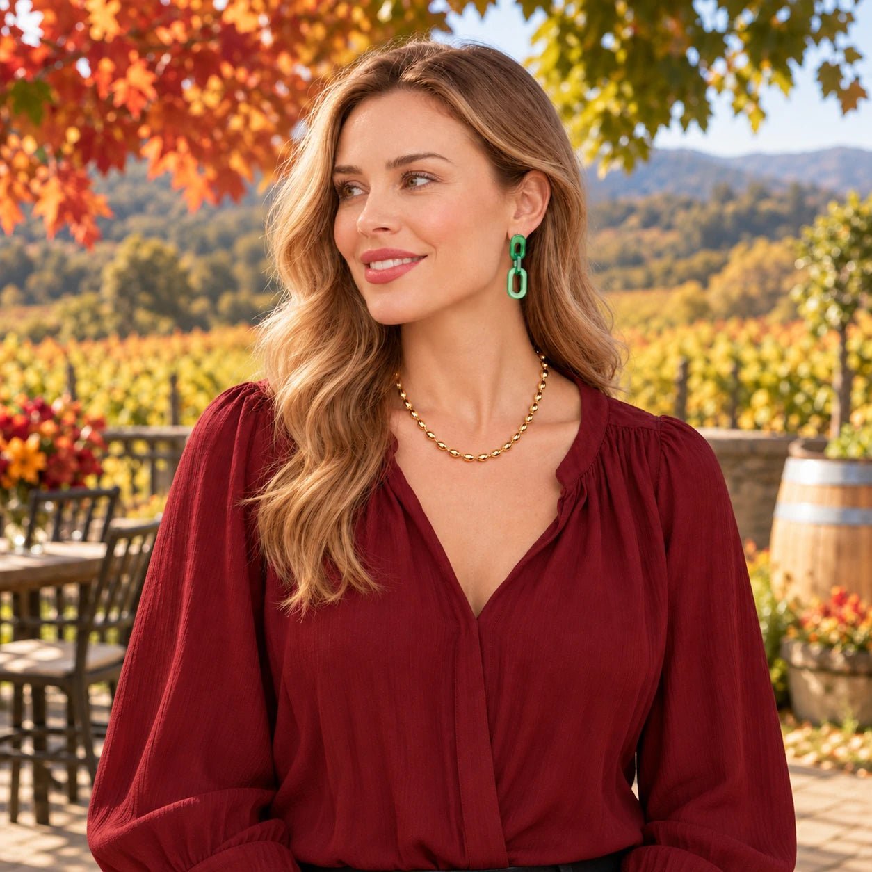 Green resin cable earrings and a gold oval-bead necklace styled together at a sunlit autumn winery